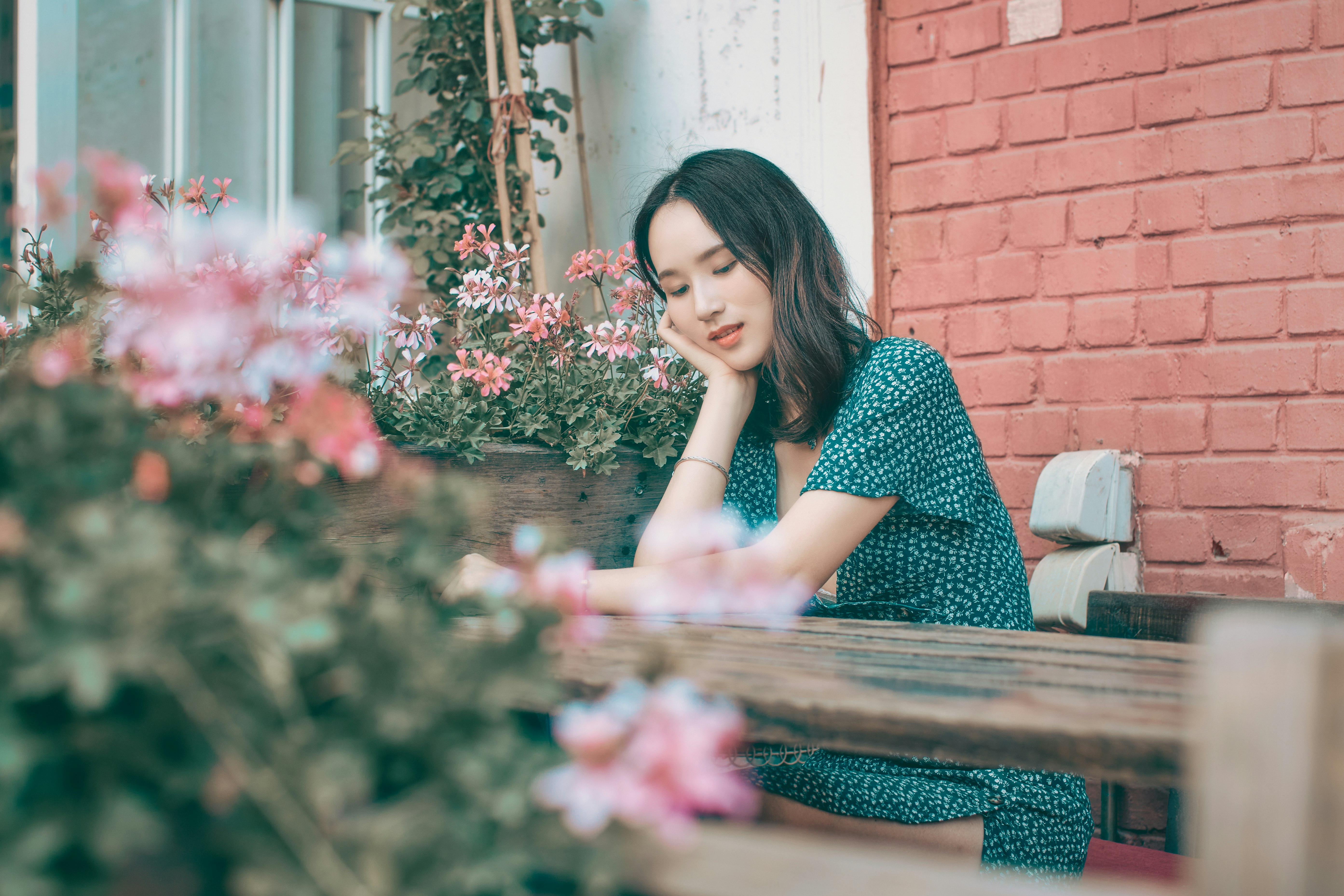 woman in black and white polka dot dress sitting on brown wooden bench